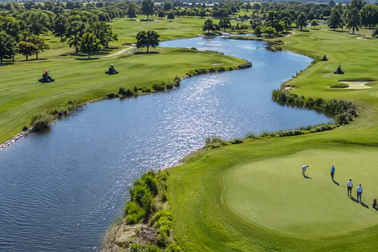 Lakeside golf hole with water guarding the approach and bunkers near the green